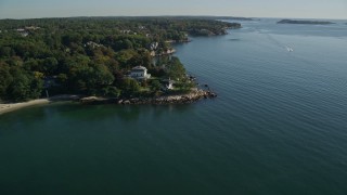 AX147_054 - 6K aerial stock footage flying by oceanfront mansions and a speedboat, Beverly, Massachusetts