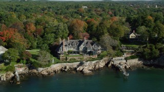 AX147_061 - 6k aerial stock footage orbiting oceanfront mansion among fall foliage, autumn, Manchester-by-the-Sea, Massachusetts