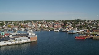AX147_087 - 6K aerial stock footage flying by coastal town, small warehouse buildings, Gloucester, Massachusetts