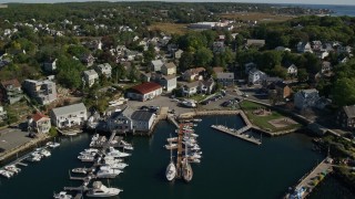 AX147_089 - 6K aerial stock footage flying over a small harbor, approach coastal town, Gloucester, Massachusetts