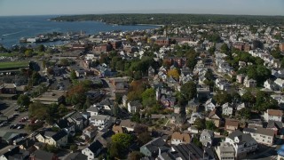 AX147_092E - 6K aerial stock footage flying over coastal town, colorful trees, Gloucester, Massachusetts