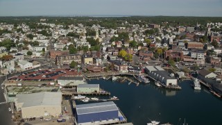 AX147_099 - 6K aerial stock footage approaching and flying over coastal town, warehouses, Gloucester, Massachusetts