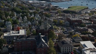 AX147_100 - 6K aerial stock footage orbiting Gloucester City Hall, coastal town, reveal harbor, Gloucester, Massachusetts