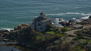AX147_107 - 6K aerial stock footage approaching oceanfront home on rocky shoreline, Gloucester, Massachusetts