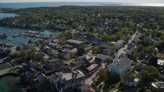 AX147_120E - 6K aerial stock footage of a coastal town and white church near the harbor, Rockport, Massachusetts