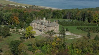 AX147_141 - 6k aerial stock footage of The Great House at Crane Estate and Castle Hill among trees in autumn, Ipswich, Massachusetts