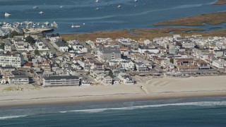 AX147_154E - 6K aerial stock footage flying by a coastal town and beach, Hampton, New Hampshire