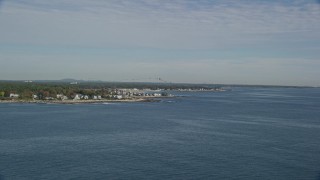 AX147_164 - 6k aerial stock footage approaching a coastal town and track flock of birds toward water, autumn, Rye, New Hampshire