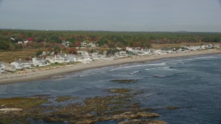 AX147_165E - 6K aerial stock footage flying by ocean and beachfront homes in autumn, Rye, New Hampshire