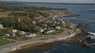 AX147_167E - 6K aerial stock footage flying over ocean toward beachfront homes in autumn, Rye, New Hampshire