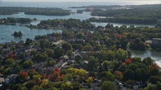 AX147_184 - 6K aerial stock footage flying over colorful autumn trees in a coastal town, Portsmouth, New Hampshire