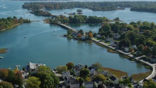 AX147_186 - 6k aerial stock footage flying over small bridge, waterfront homes in autumn, Portsmouth, New Hampshire