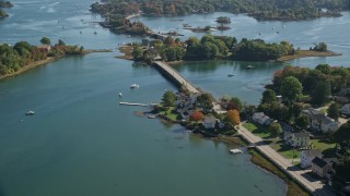 AX147_186E - 6K aerial stock footage flying over small bridge, waterfront homes in autumn, Portsmouth, New Hampshire