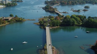 AX147_187 - 6k aerial stock footage flying over small bridge and waterfront homes in autumn, Portsmouth, New Hampshire