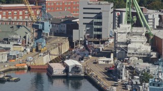 AX147_188 - 6K aerial stock footage flying by a submarine in a naval shipyard, Kittery, Maine