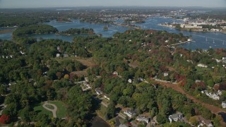 AX147_199 - 6k aerial stock footage flying over autumn trees in a coastal town, New Castle, Portsmouth, New Hampshire