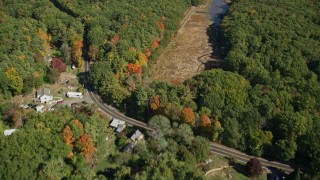 AX147_228E - 6K aerial stock footage of a bird's eye view of colorful forest, rural homes, revealing a river, Kittery, Maine