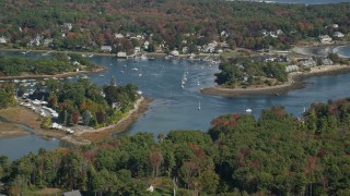 AX147_230E - 6K aerial stock footage flying over colorful forest, rural homes, reveal York Harbor, Kittery and York, Maine