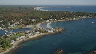 AX147_232 - 6k aerial stock footage approaching small coastal town, York Harbor, beach, autumn, York, Maine