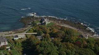 AX147_234 - 6k aerial stock footage approaching upscale oceanfront homes, rocky shore, autumn, York, Maine