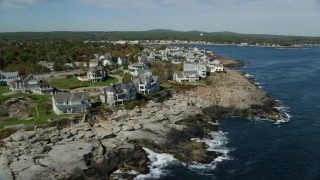 AX147_243 - 6k aerial stock footage flying by oceanfront mansions, rocky coast, autumn, York, Maine