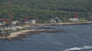 AX147_257E - 6K aerial stock footage flying by oceanfront mansions, rocky coastline, autumn, Kennebunkport, Maine
