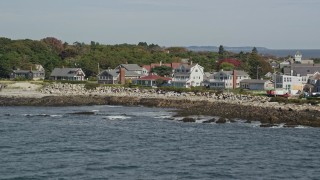 AX147_267E - 6K aerial stock footage tilting up revealing oceanfront homes, Wood Island Light, Biddeford, Maine