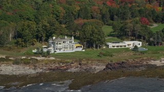 AX147_301 - 6K aerial stock footage flying by oceanfront mansions, colorful autumn trees, Cape Elizabeth, Maine