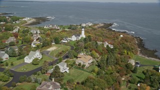 AX147_304E - 6K aerial stock footage flying over coastal town, Cape Elizabeth Light, autumn, Cape Elizabeth, Maine
