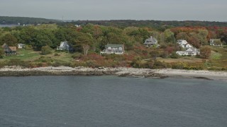 AX147_317 - 6k aerial stock footage flying by oceanfront homes, Cushing Island, autumn, Portland, Maine
