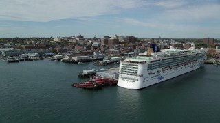 AX147_322 - 6k aerial stock footage flying by docked cruise ship, piers and downtown, autumn, Portland, Maine
