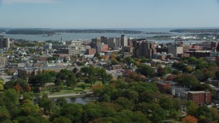 AX147_357 - 6k aerial stock footage flying by downtown office buildings, colorful autumn trees, Portland, Maine