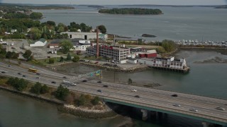 AX147_359E - 6K aerial stock footage approaching Tukey's Bridge, Interstate 295, small factory, Portland, Maine