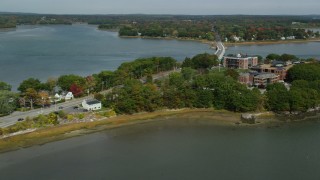 AX147_361 - 6k aerial stock footage flying by waterfront homes, approach office buildups, small bridge, Portland, Maine
