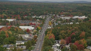 AX147_365E - 6K aerial stock footage flying by Route 1, small town in autumn, Falmouth, Maine