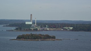AX147_368 - 6k aerial stock footage flying by Wyman Energy Center on a cloudy day in autumn, Yarmouth, Maine