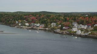 AX147_398 - 6K aerial stock footage flying over waterfront homes, colorful trees in autumn, Georgetown, Maine