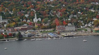 AX147_414 - 6K aerial stock footage flying by small waterfront town, church, autumn, Bath, Maine