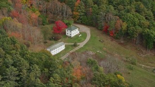 AX147_417 - 6K aerial stock footage flying by rural homes, tilt down, autumn, Woolwich, Maine