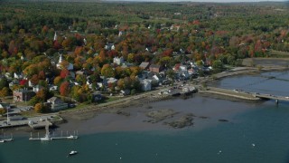 AX148_005 - 6k stock footage aerial video approaching small waterfront town, tilt down, Main Street, autumn, Wiscasset, Maine
