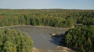 AX148_016E - 6K aerial stock footage flying over Damariscotta River, forest, isolated homes, autumn, Damariscotta, Maine
