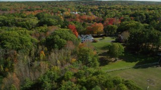 AX148_017 - 6k aerial stock footage approaching an isolated home, colorful forest, autumn, Damariscotta, Maine