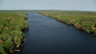 AX148_022 - 6k aerial stock footage flying by a colorful forest, over Biscay Pond, autumn, Damariscotta, Maine