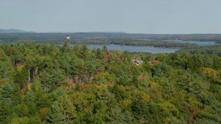 AX148_027 - 6k aerial stock footage flying over colorful forest, by watchtower, approach Broad Cove, Bremen, Maine