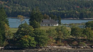 AX148_030 - 6K aerial stock footage flying by an isolated rural home, autumn, Waldoboro, Maine