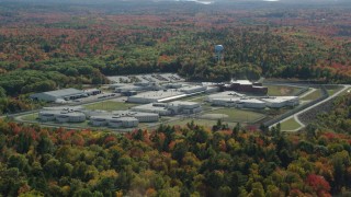 AX148_066 - 6k stock footage aerial video orbiting Maine State Prison, colorful forest, autumn, Warren, Maine