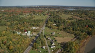 AX148_067E - 6K aerial stock footage of small bridges, Highway 1 over river, and rural homes, autumn, Thomaston, Maine