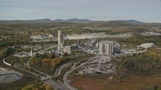 AX148_074 - 6K aerial stock footage flying by quarry and factory, scattered fall foliage, autumn, Thomaston, Maine