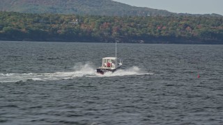AX148_088 - 6k aerial stock footage tracking a fishing boat, colorful foliage, autumn, Owls Head, Maine