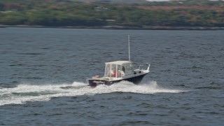AX148_089 - 6K aerial stock footage tracking a speeding boat on the water, Owls Head, Maine
